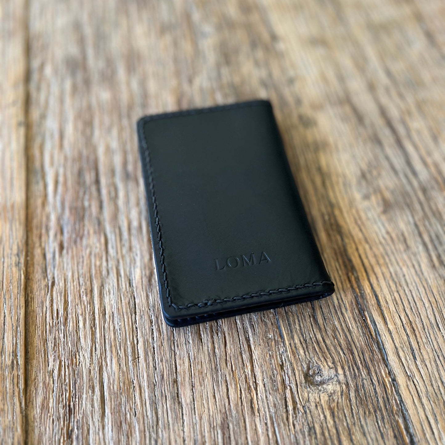 Back view of a black italian leather bi-folding wallet