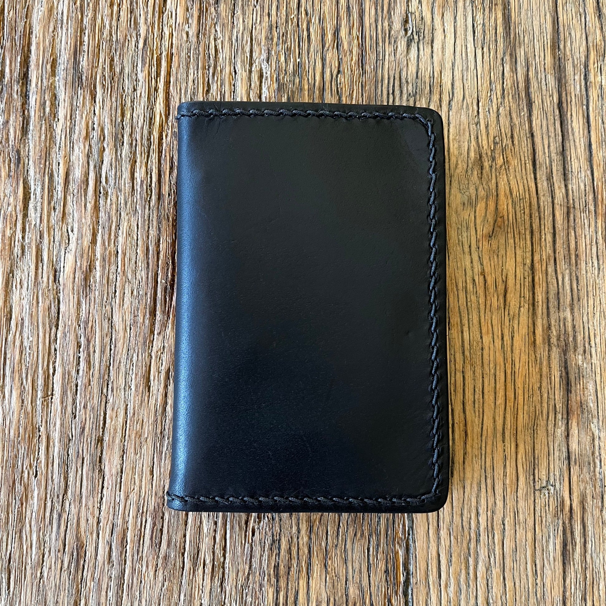 Front view of a black italian leather bi-folding wallet