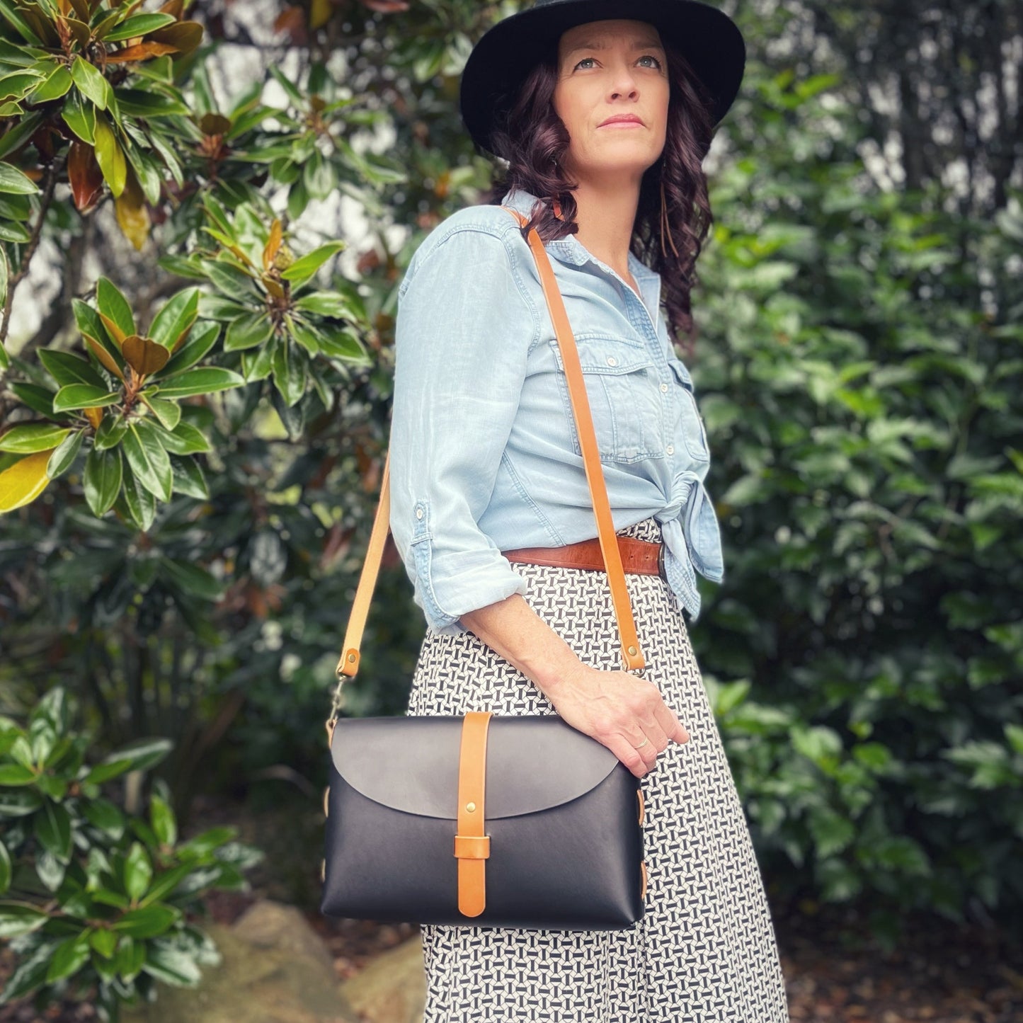 Black and tan leather crossbody bag with woven side construction