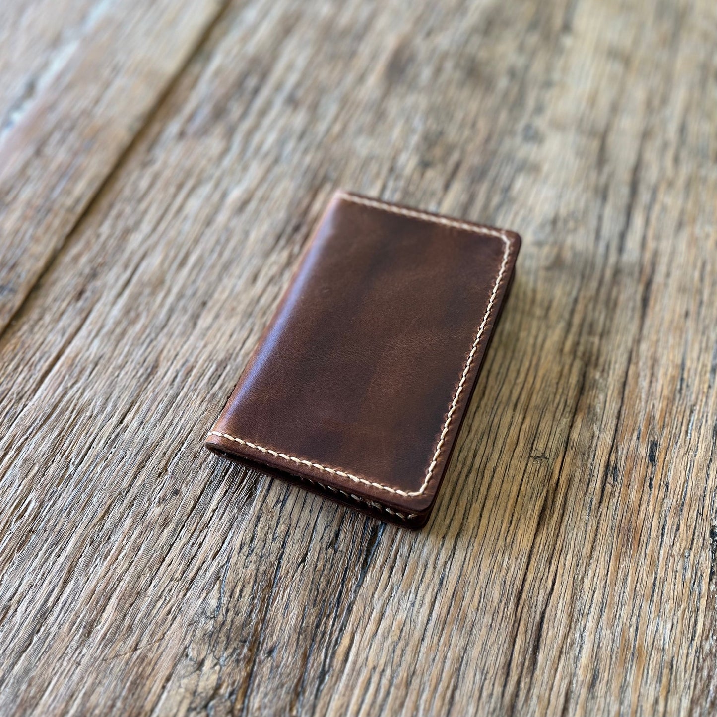 Front view of a brown italian leather bi-folding wallet
