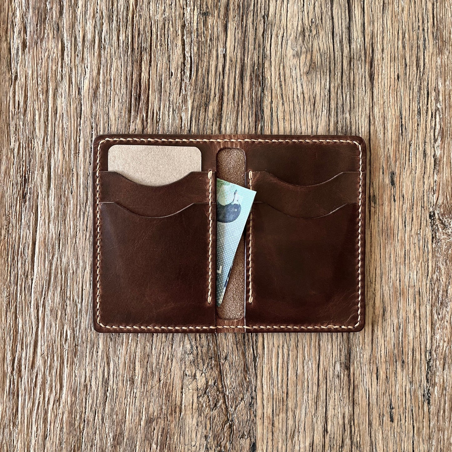 Open view of a brown italian leather bi-folding wallet