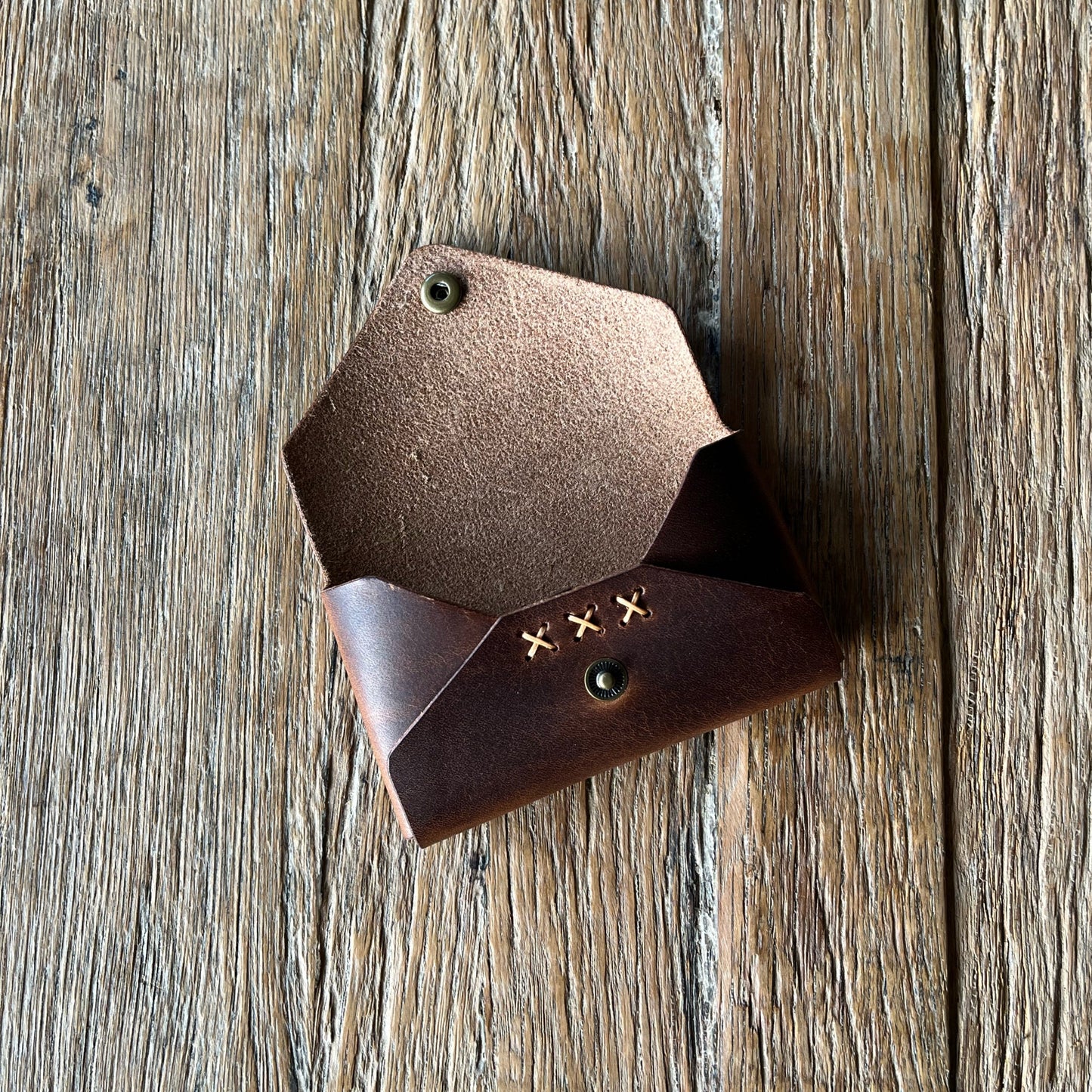 Brown leather wallet on a wooden surface