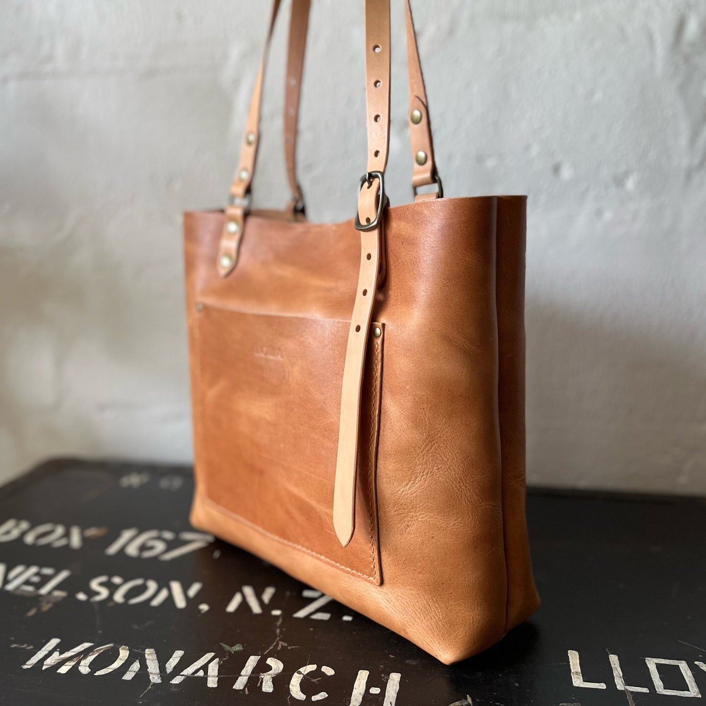 Natural coloured leather tote bag with a neutral background