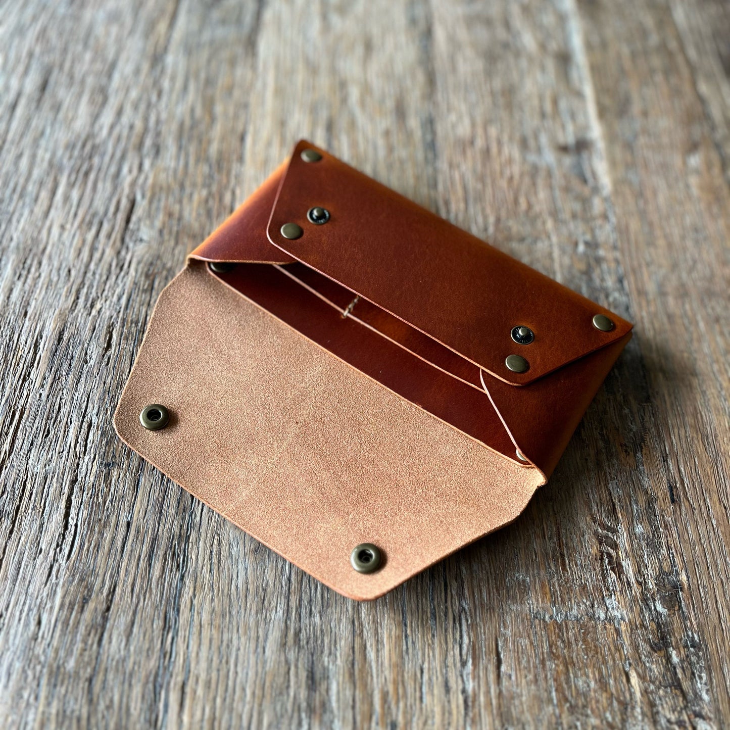 Brown leather wallet on a wooden surface