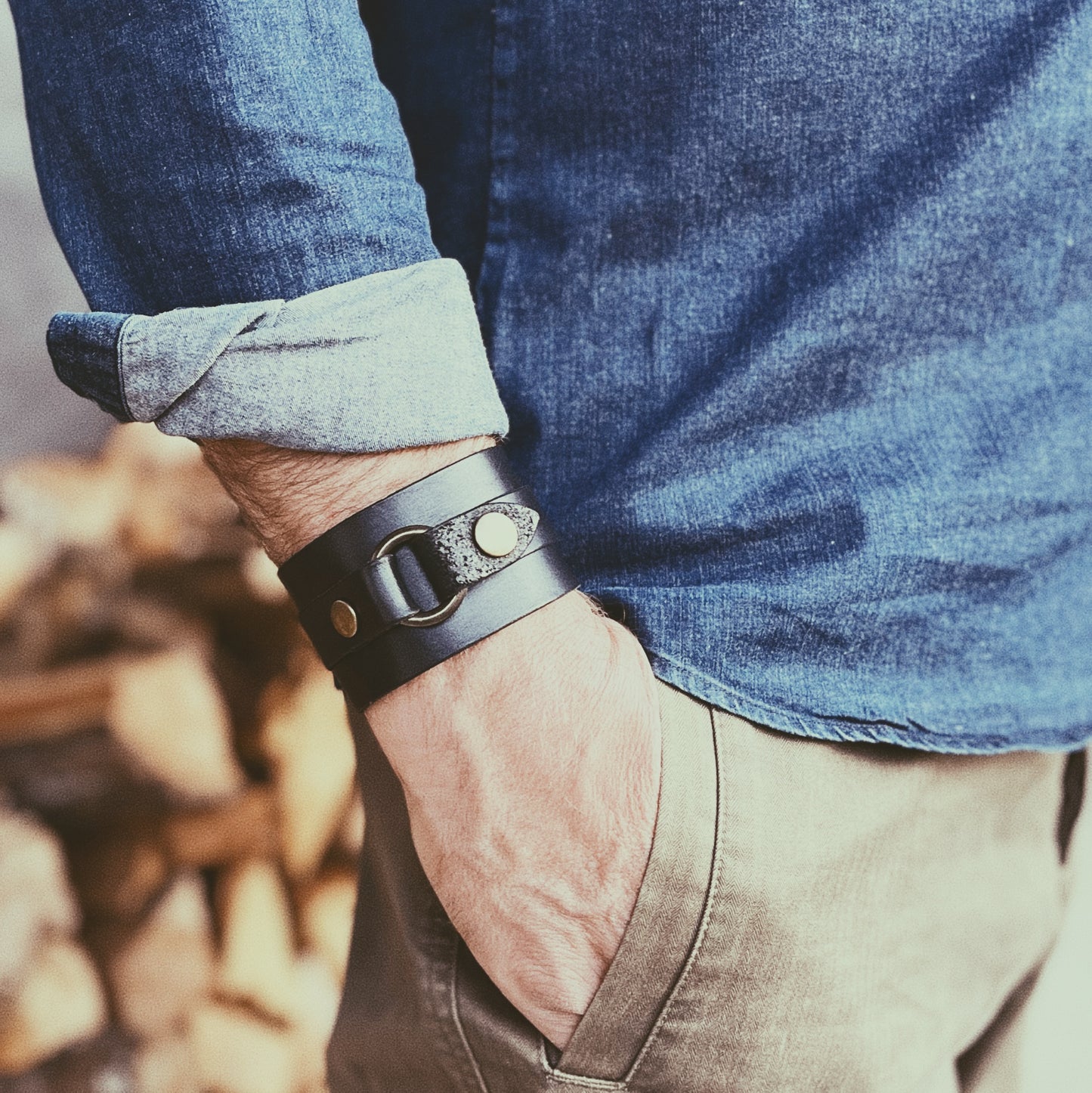 Person wearing a leather bracelet with a blurred background