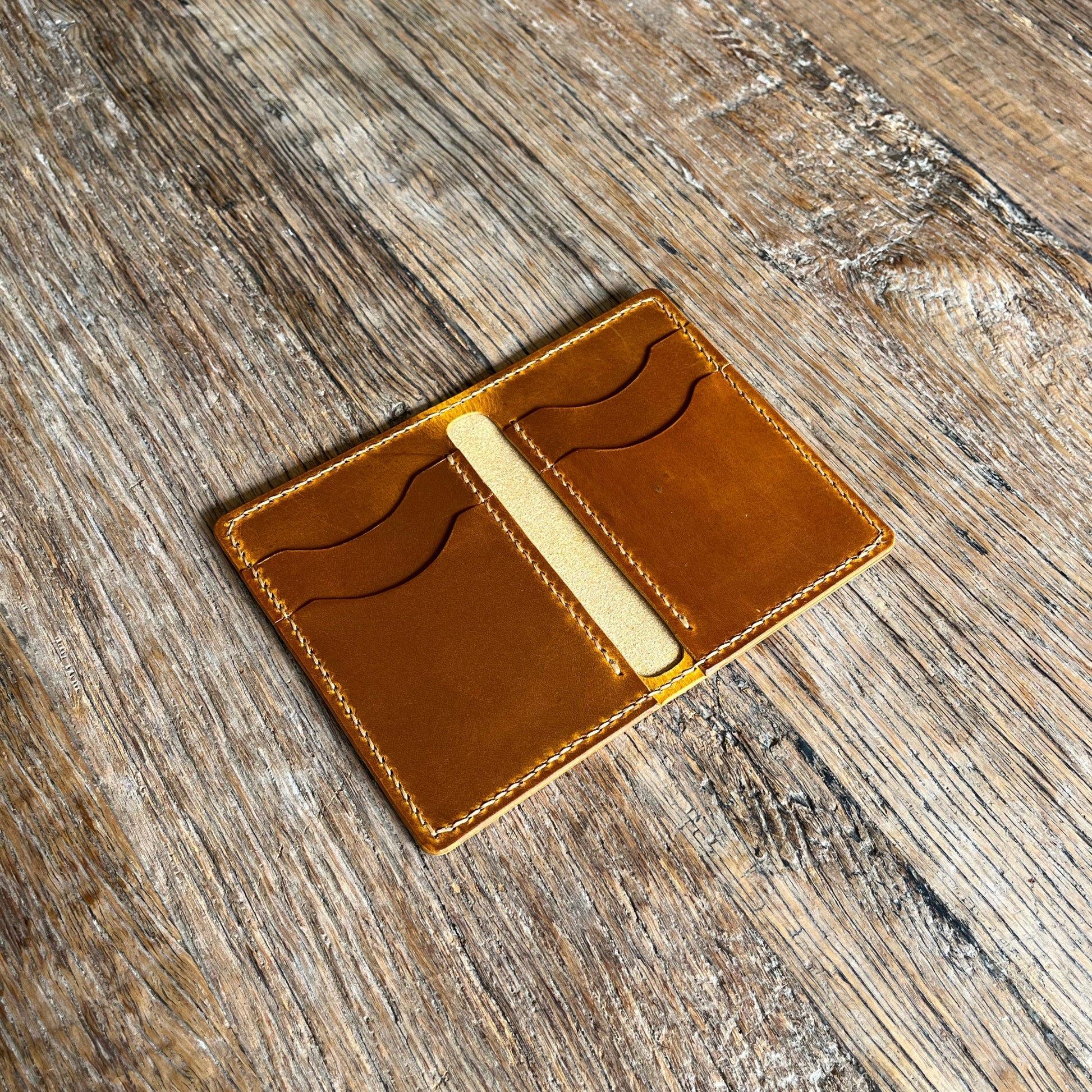 Brown leather wallet on a wooden surface