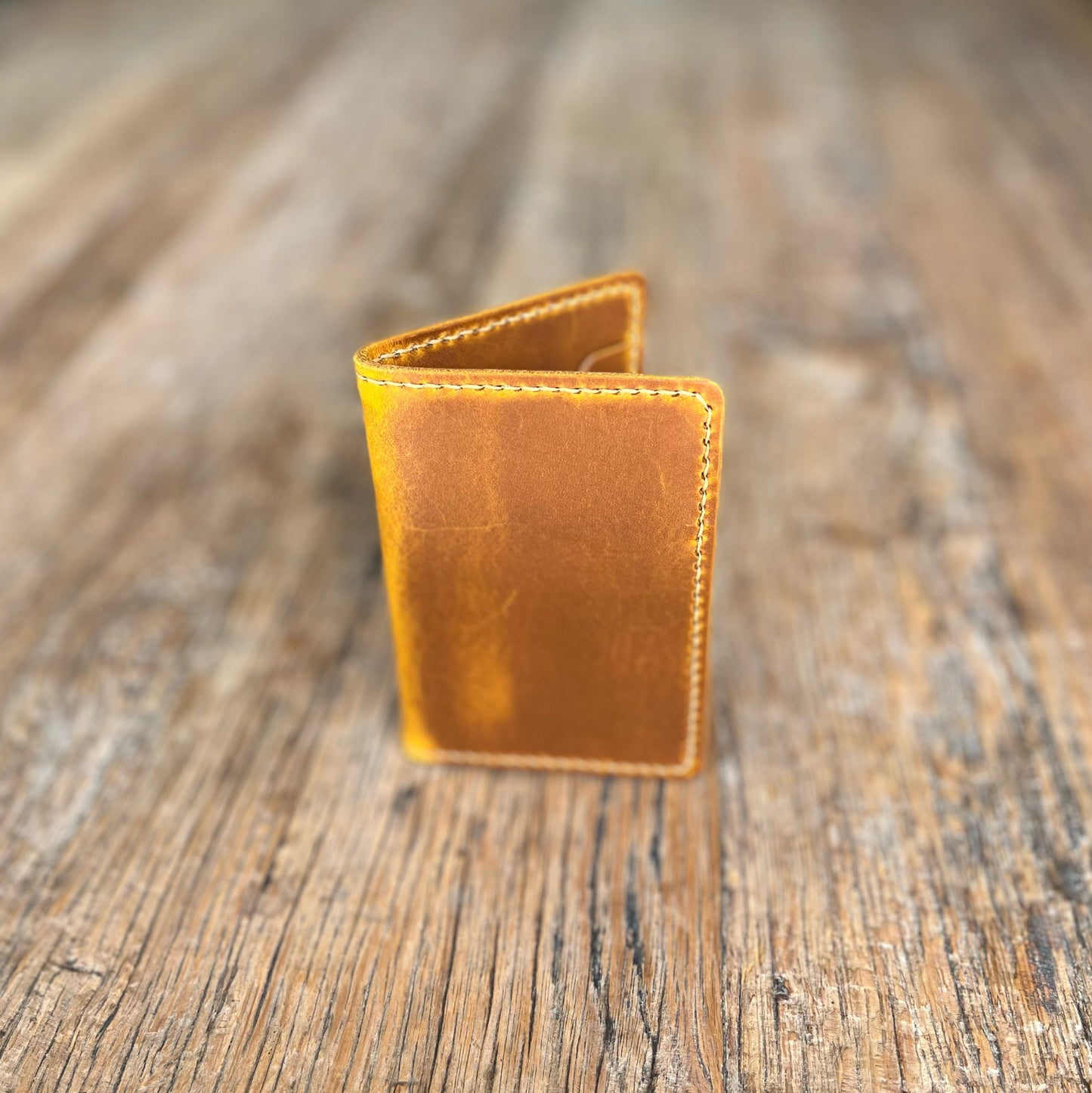 Brown leather wallet on a wooden surface