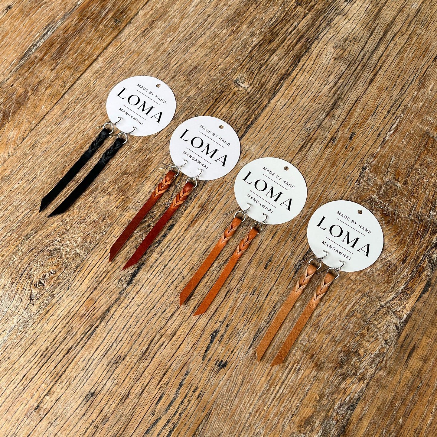 Set of LOMA leather earrings on a wooden surface
