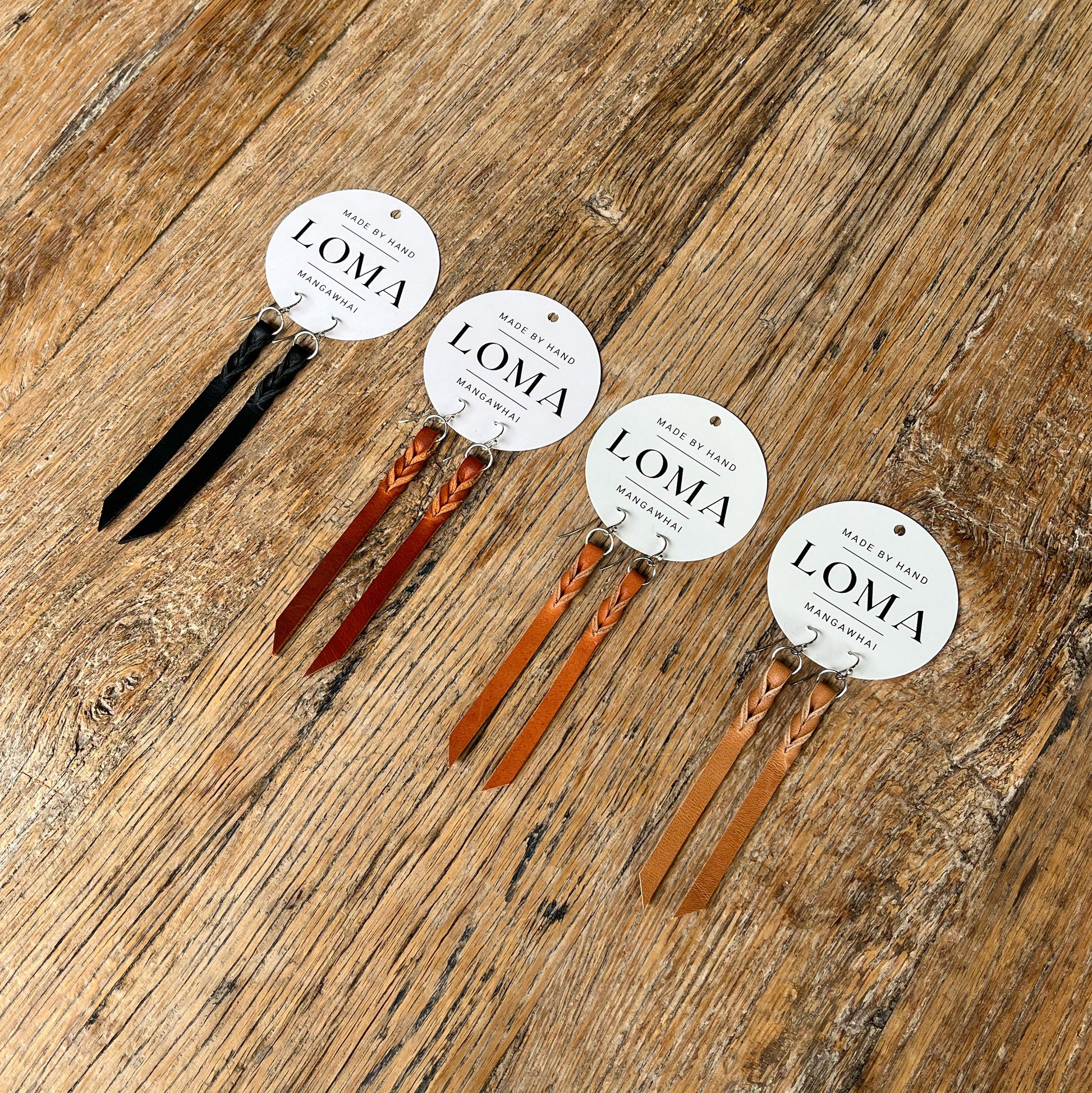 Set of LOMA leather earrings on a wooden surface