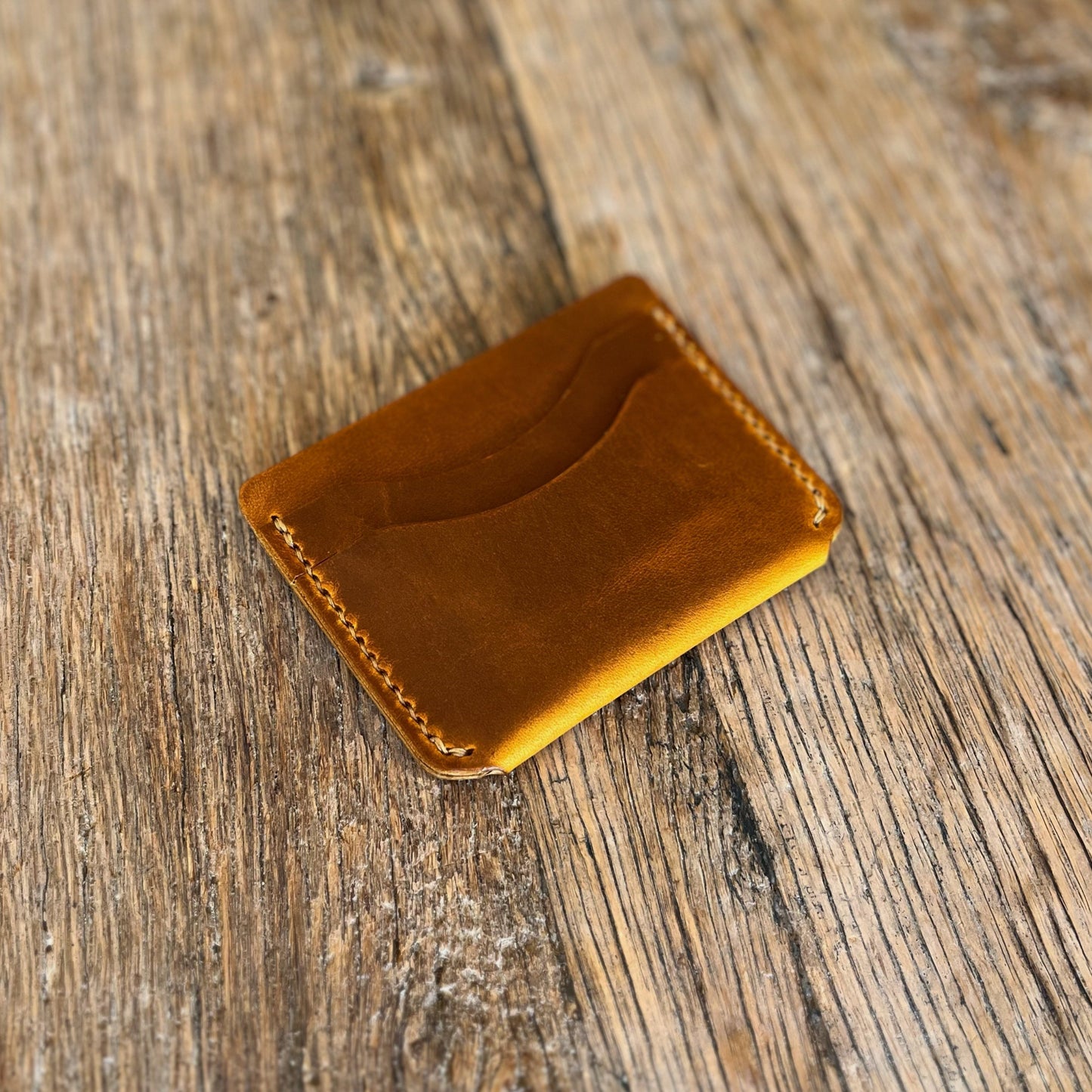 Brown leather wallet on a wooden surface